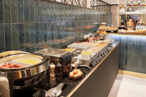 a buffet line in a restaurant with food at Best Western Premier Hotel des Vignes et des Anges in Pauillac