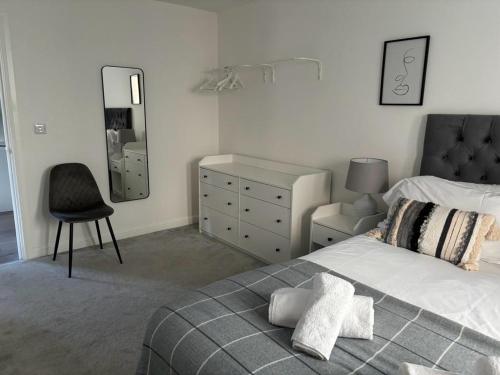 a bedroom with a bed and a chair and a dresser at Exquisite Long-Term Living in Cardiff's Heart in Cardiff