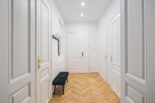 un pasillo con puertas blancas y un taburete negro en Brand Cozy Apartment, en Viena