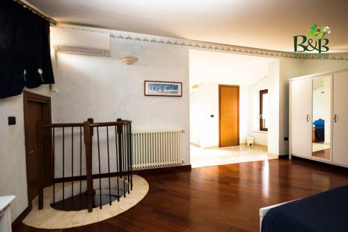 a living room with a wooden floor and a staircase at B&B dell'Aviatore in San Liberato