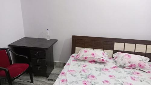 a bedroom with a bed and a dresser with pink flowers at Darbar Homestay in Gaya