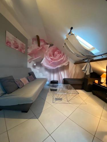 - un salon avec un canapé et des fleurs sur le mur dans l'établissement studio cosy à 35 mn de Paris., à Corbeil-Essonnes
