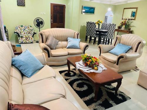 a living room with couches and a coffee table at St Eldo in Arima