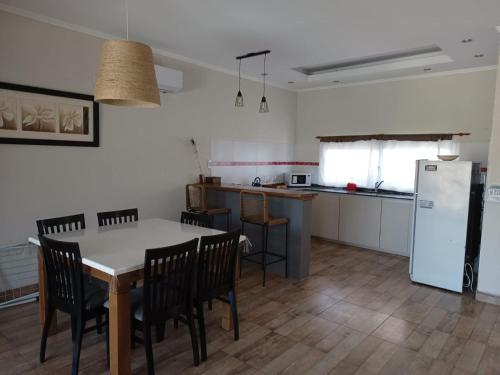 eine Küche mit Tisch und Stühlen und einem Kühlschrank in der Unterkunft A mi manera - Casa de Sierra in Villa Giardino