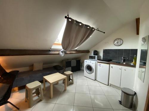 - une cuisine avec un canapé et une table dans une chambre dans l'établissement studio cosy à 35 mn de Paris., à Corbeil-Essonnes