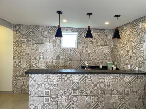 a kitchen with a counter and a tile wall at Anexo Marques in Paraty