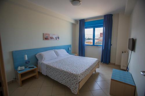 sypialnia z łóżkiem i dużym oknem w obiekcie Residence Miljunka w mieście SantʼAgata di Militello