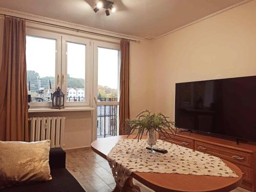 a living room with a television and a coffee table at APARTAMENT CENTRUM Międzychód in Międzychód