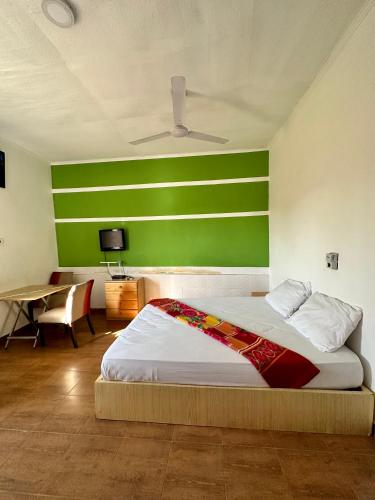 um quarto com uma cama com uma parede verde em My Place Guest House em Ho