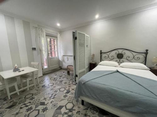 a bedroom with a bed and a table and a desk at Il leccione in Bagni San Filippo