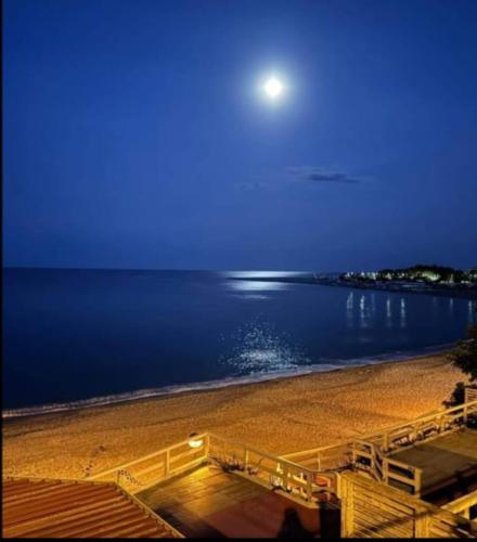 a view of a beach at night with a full moon at Maison Manni' B&B in Soverato Marina