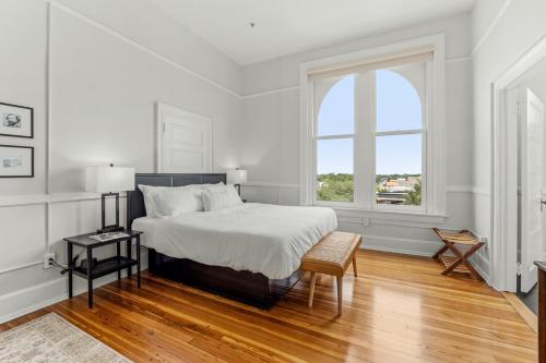 um quarto branco com uma cama e uma janela em The McKey em Valdosta