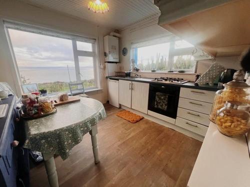 a kitchen with a table and a large window at Tranquilty in Ballyheigue