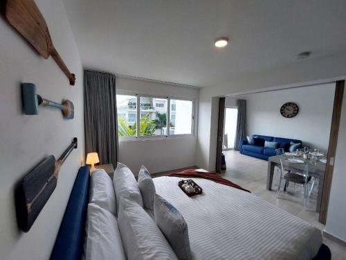 a bedroom with a large bed with a couch at Seaside Luxury 1BDR Condo Paseo Playa Coral D-306 in Punta Cana
