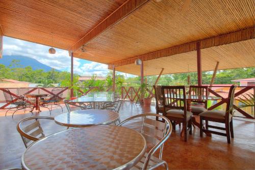 a patio with tables and chairs with a view at La Fortuna Lodge by Treebu Hotels in Fortuna