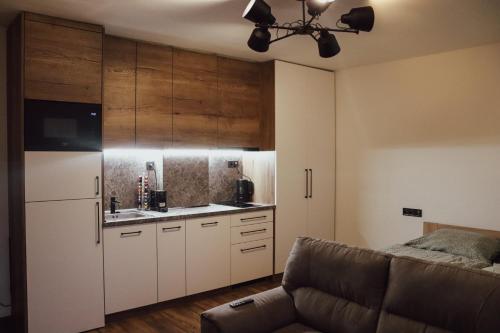 a kitchen with white cabinets and a couch at IQ Apartments in Prešov
