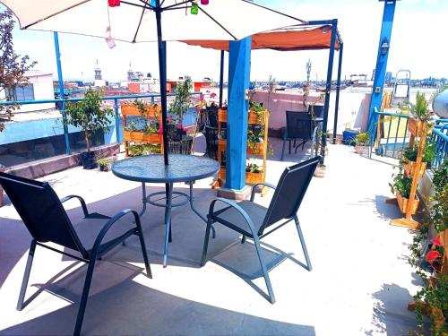 a table and chairs with an umbrella on a patio at CASONA SANTA MARTA in Arequipa