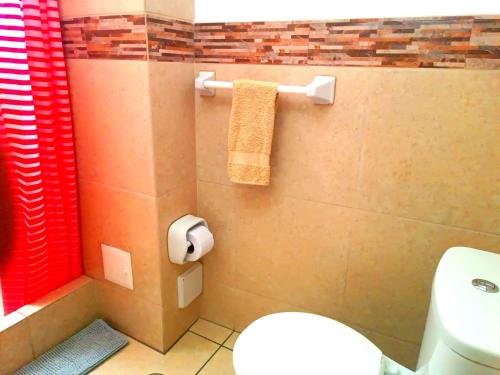 a bathroom with a toilet and a red shower curtain at CASONA SANTA MARTA in Arequipa