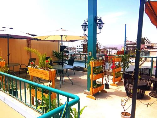 a balcony with tables and chairs and an umbrella at CASONA SANTA MARTA in Arequipa