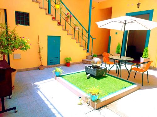 a patio with a table and an umbrella next to a building at CASONA SANTA MARTA in Arequipa
