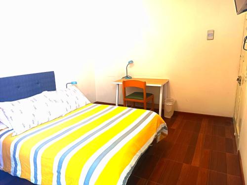 a bedroom with a bed and a desk with a lamp at CASONA SANTA MARTA in Arequipa