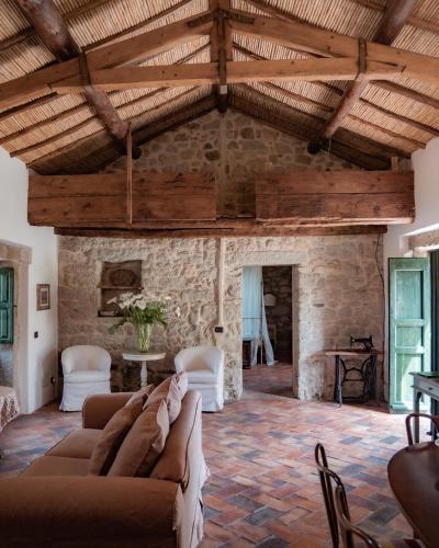 a living room with a couch and a stone wall at Stazzo Lu Ciaccaru in Arzachena