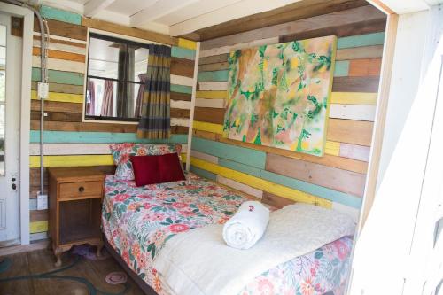 a bedroom with a bed and a wooden wall at Casa Tavaita in Karangahake gorge in Paeroa