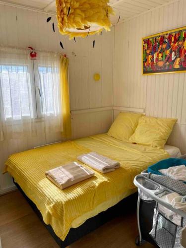 - une chambre avec un lit jaune et 2 serviettes dans l'établissement Chalet vue sur mer, à Gruissan