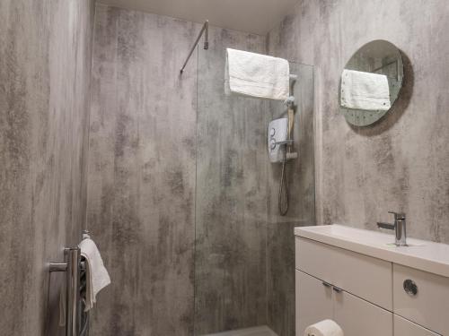 een badkamer met een douche, een wastafel en een spiegel bij 4 Boulby Bank Top in Whitby