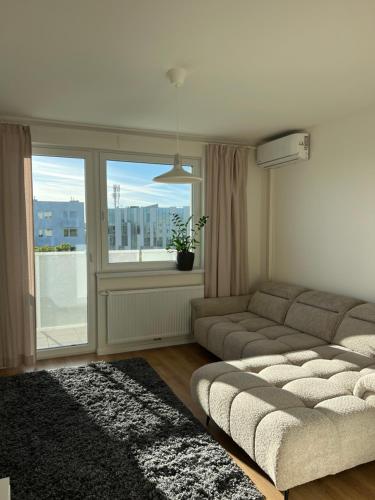 ein Wohnzimmer mit einem Sofa und einem Fenster in der Unterkunft Contemporary Airport Retreat in Prievoz