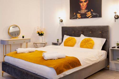 a bedroom with a large bed with yellow pillows at Casa Paul in Braşov