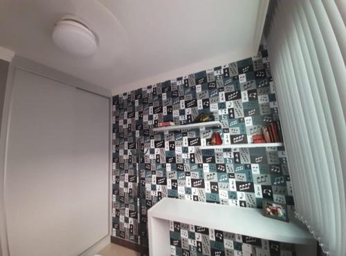 um quarto com uma parede coberta de imagens numa parede em Apartamento Completo e Aconchegante em Lagoa Santa