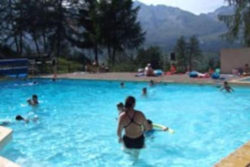 un groupe de personnes se baignant dans une grande piscine dans l'établissement CHALET LUXE, 8-10 Pers, Parking, Sauna, Wifi, Netflix, Recommandé par locataires, à Saint-Étienne-en-Dévoluy