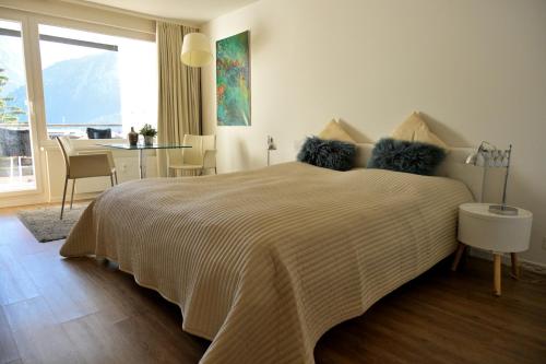 um quarto com uma cama com uma mesa e uma janela em ArosaFlair em Arosa