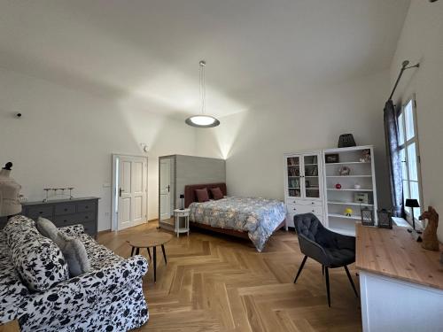 uma sala de estar com um sofá e uma cama em Kaštieľ Ladce 