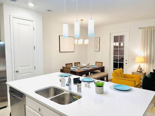 a kitchen with a sink and a living room at Townhouse in Champions Gate in Davenport