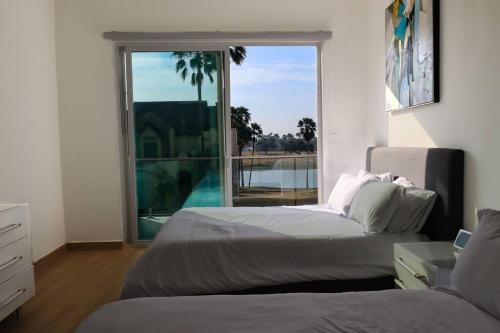a bedroom with two beds and a large window at Lake Home: Relax and Unwind in Mission Hidden Gem in Mission