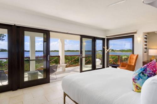 a bedroom with a bed and views of the ocean at Songbird 4 BR Anguilla Villa in The Valley