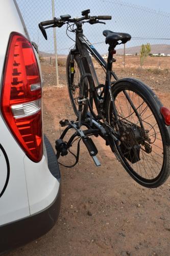 una bicicleta está pegada a la parte trasera de un coche en FurgoCamper Van H1, en Tetir