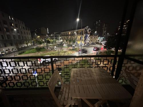a wooden bench sitting on a balcony at night at Gigli, rooms con cucina in comune e terrazza in Milan