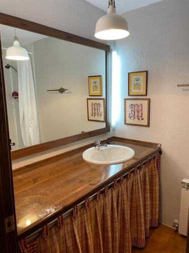a bathroom with a sink and a large mirror at Apartamento Rincon del cielo in Benasque