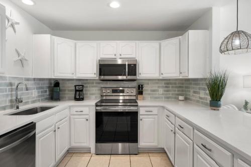 a white kitchen with a stove and a microwave at Sand Buckets Unit B, Ocean View Beach Townhouse in Mexico Beach
