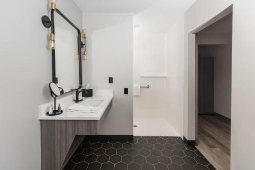 a bathroom with a sink and a mirror at The Farmstead Hotel in Caruthersville