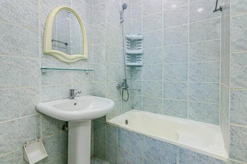 uma casa de banho com um lavatório, um espelho e uma banheira em Apartment Simit em Baku