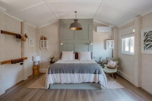 a bedroom with a large bed and a chair at The River Stables 