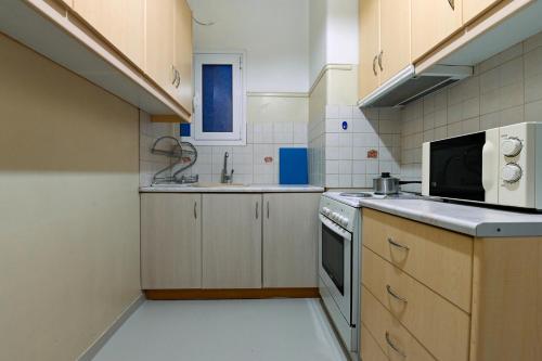 Una pequeña cocina con fregadero y microondas. en Athens Retreat 1-BDR Apartment by WeHost Athens, en Atenas