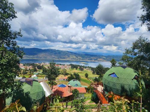 a view of a camp with a lake in the background at Glamping sede campestre Mirador de Pueblo Viejo in Guatavita