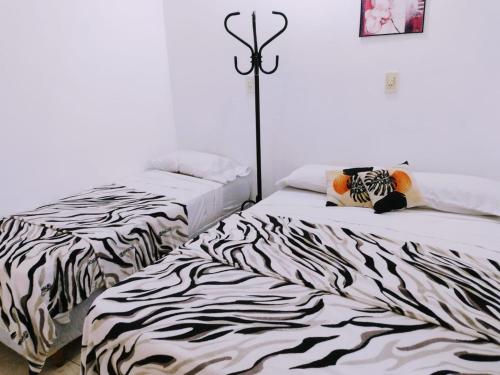two beds sitting next to each other in a bedroom at Departamentos la cascada in Termas de Río Hondo
