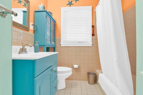 Baño azul con aseo y lavamanos en Tranquility by the Beach, Sleeps 6, en Lake Worth