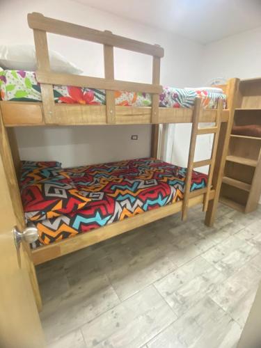 a bedroom with two bunk beds with a colorful blanket at 22 APARTAMENTO 3 habitaciones CON BALCON EN LAURELES ESTADIO in Medellín
